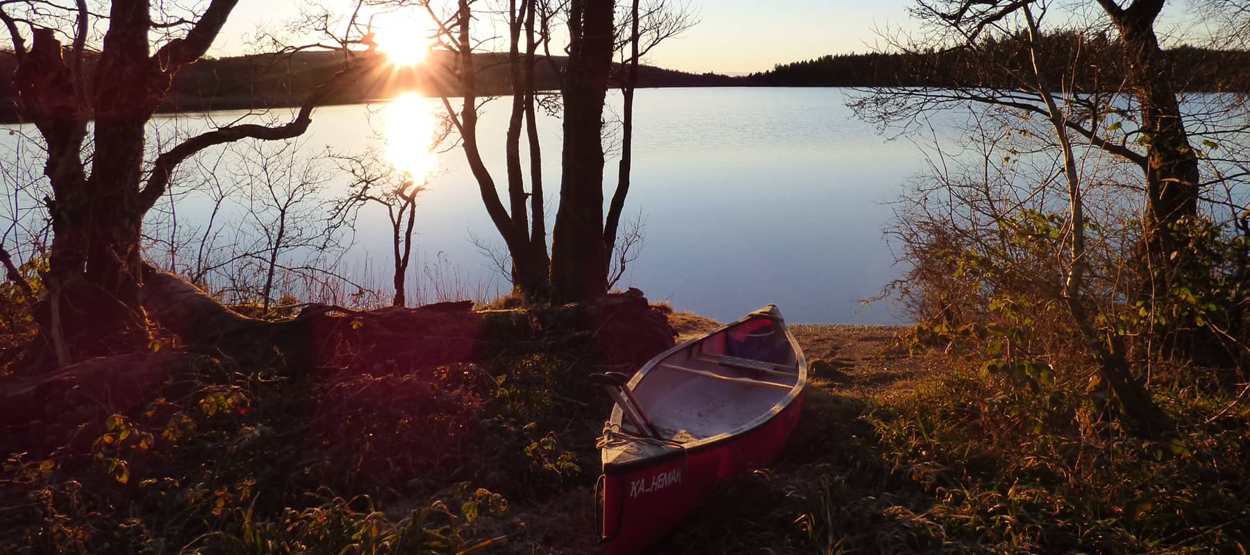 Image of canoe lakeside at sunset. Online funding applications page image.